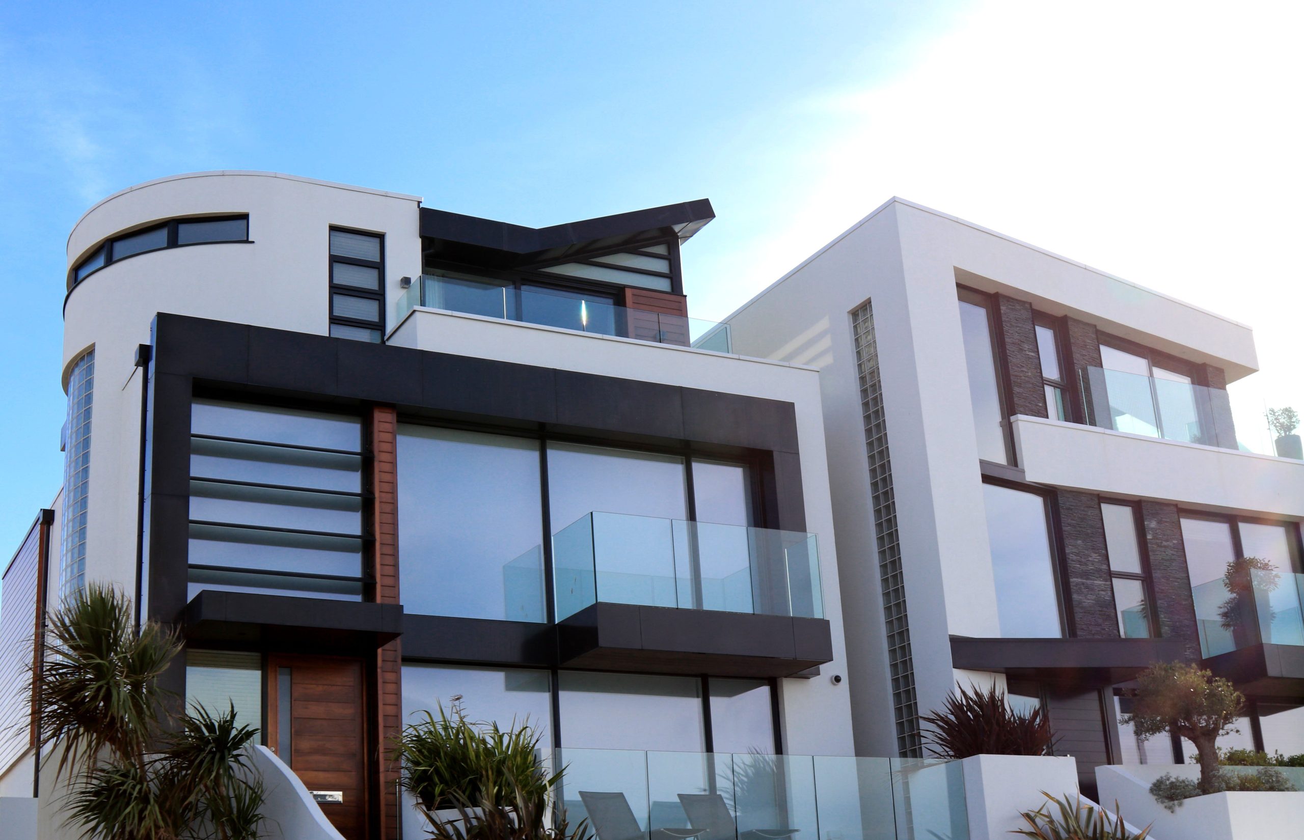 Services Contemporary luxury home with glass balconies in Poole, UK, showcasing modern architectural design.